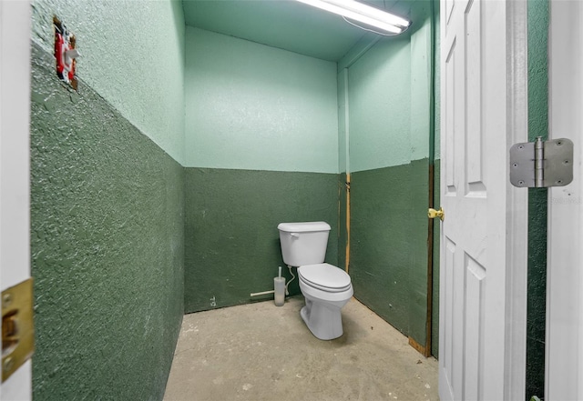 bathroom with concrete floors and toilet