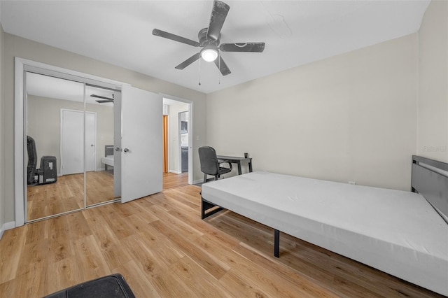 bedroom with ceiling fan, wood-type flooring, and a closet