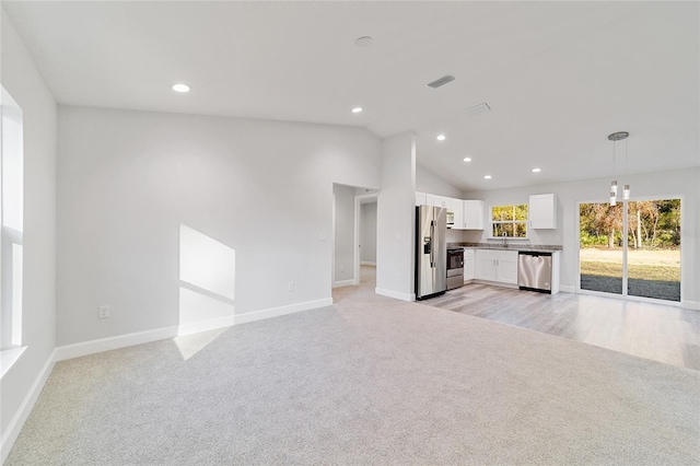 unfurnished living room featuring lofted ceiling, sink, and light carpet