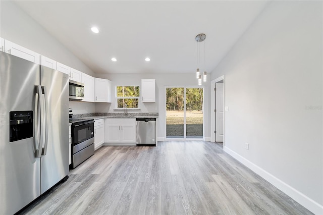 kitchen with sink, decorative light fixtures, vaulted ceiling, stainless steel appliances, and white cabinets