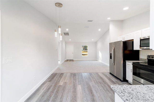 kitchen featuring pendant lighting, light stone counters, white cabinets, and appliances with stainless steel finishes