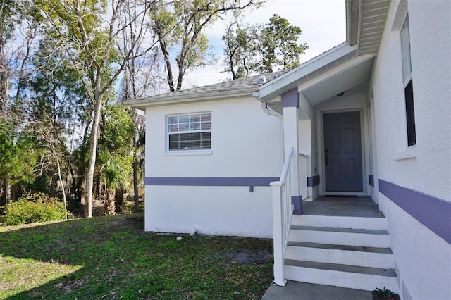 entrance to property with a lawn