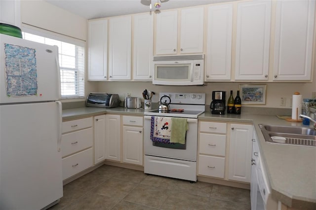 kitchen featuring light tile patterned flooring, sink, white cabinets, and white appliances