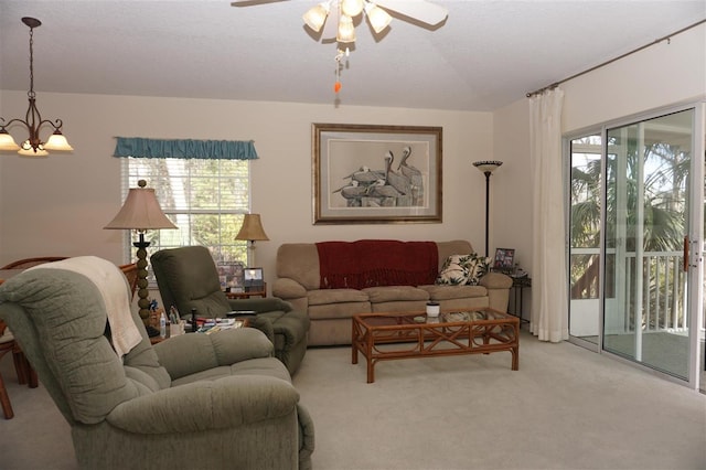 living room with carpet and ceiling fan with notable chandelier