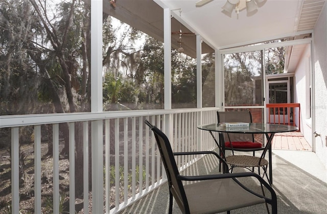 unfurnished sunroom featuring ceiling fan