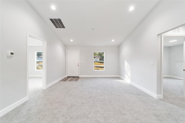 unfurnished room featuring light carpet