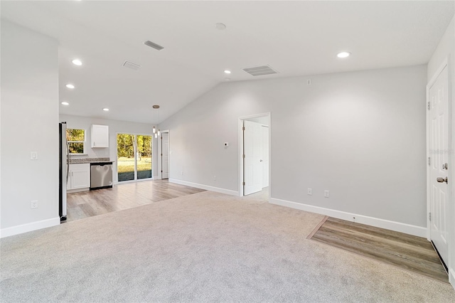 unfurnished living room featuring lofted ceiling and light colored carpet