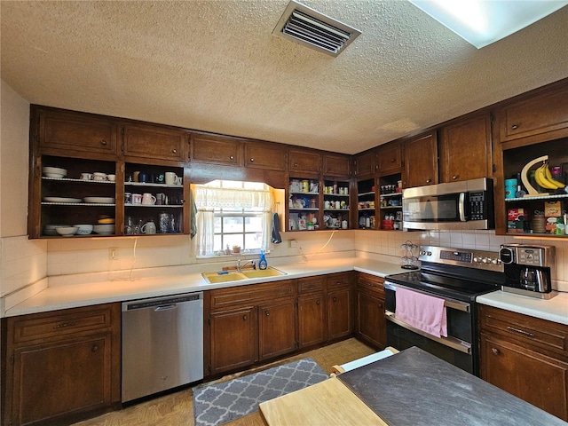 kitchen with stainless steel appliances, tasteful backsplash, dark brown cabinets, and sink