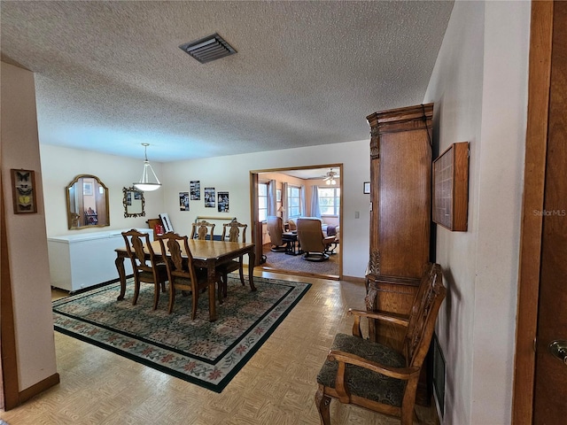 dining space featuring light hardwood / wood-style flooring and a textured ceiling