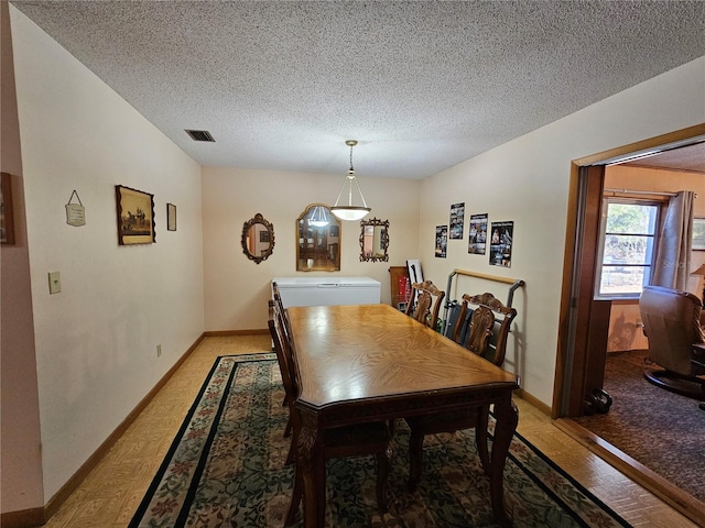 dining room featuring a textured ceiling and light hardwood / wood-style flooring