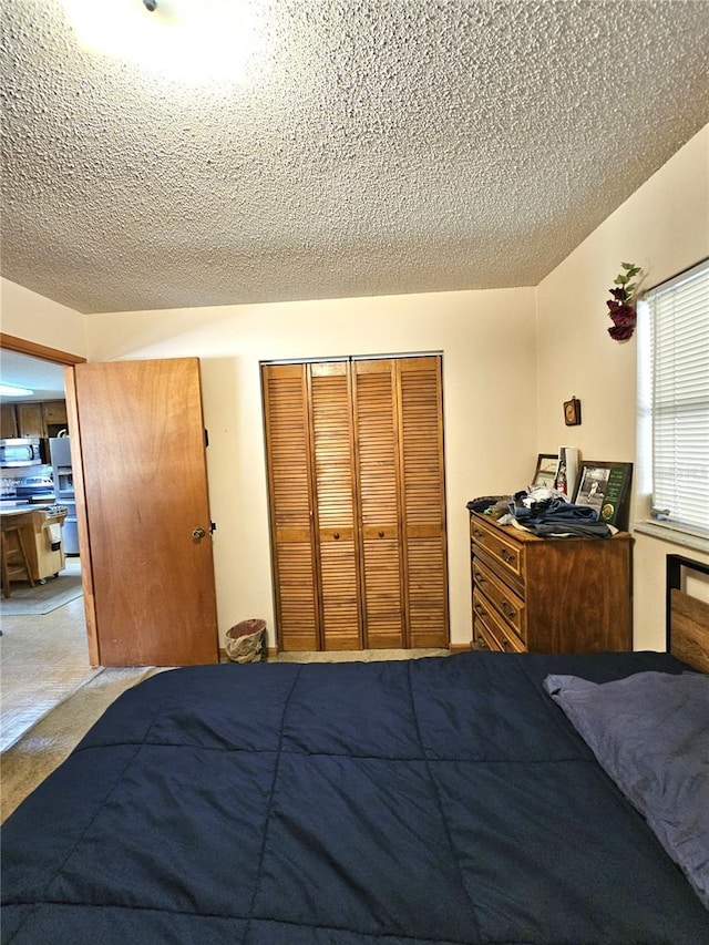 bedroom featuring carpet, a closet, and a textured ceiling