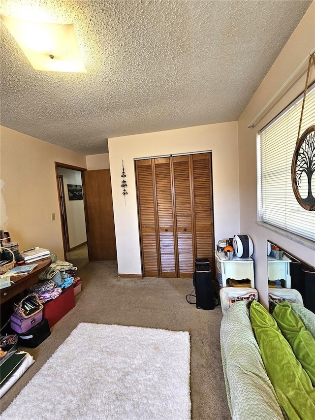 carpeted bedroom with a textured ceiling and a closet