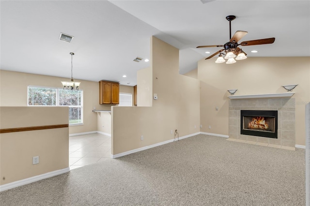 unfurnished living room featuring lofted ceiling, a fireplace, ceiling fan with notable chandelier, and light carpet