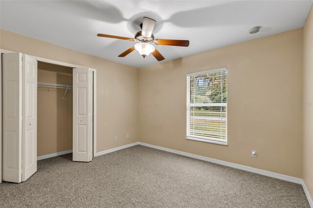 unfurnished bedroom featuring carpet floors, a closet, and ceiling fan