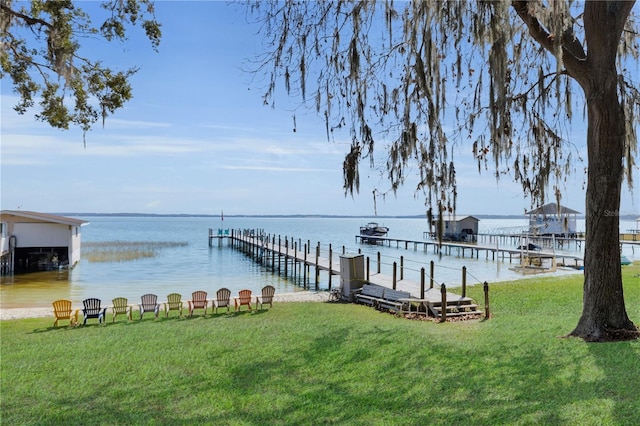 view of dock featuring a lawn and a water view