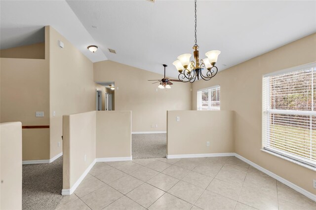 tiled spare room featuring lofted ceiling and ceiling fan with notable chandelier