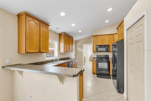 kitchen featuring a breakfast bar, kitchen peninsula, and black appliances