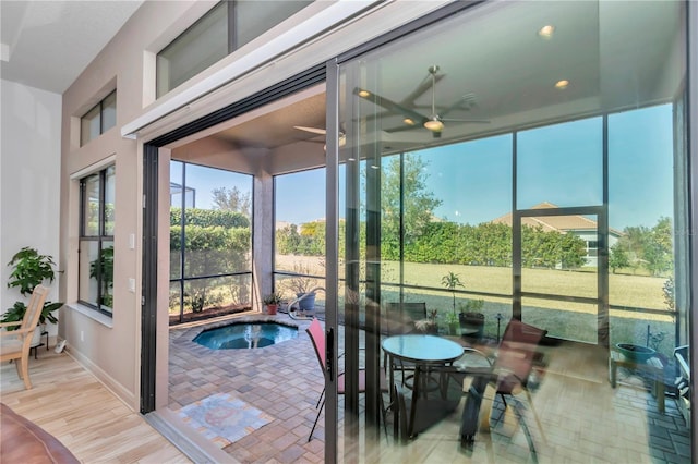 sunroom / solarium featuring ceiling fan