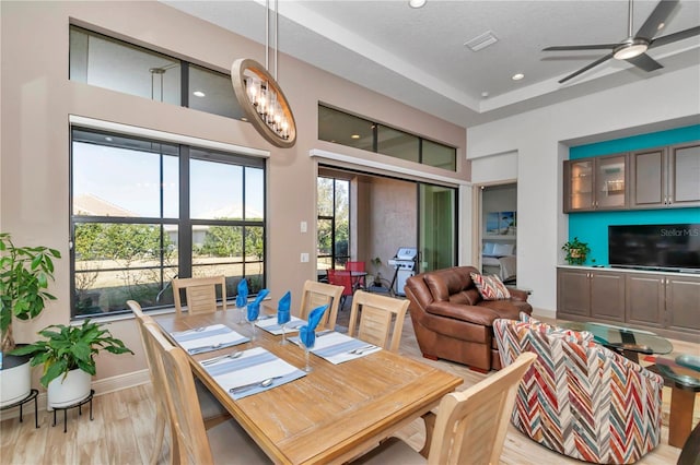 dining area with ceiling fan, a textured ceiling, and light hardwood / wood-style floors