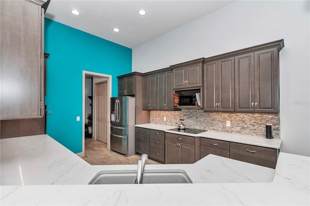 kitchen featuring sink, dark brown cabinetry, and black appliances