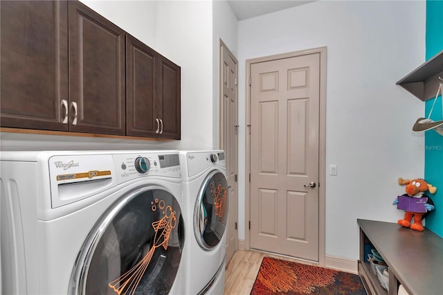 laundry room with cabinets, light wood-type flooring, and independent washer and dryer