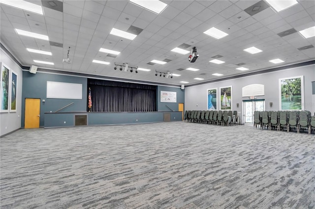 empty room with rail lighting, carpet flooring, and a drop ceiling