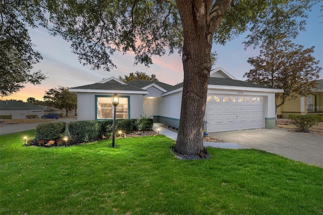 ranch-style house featuring a garage and a lawn