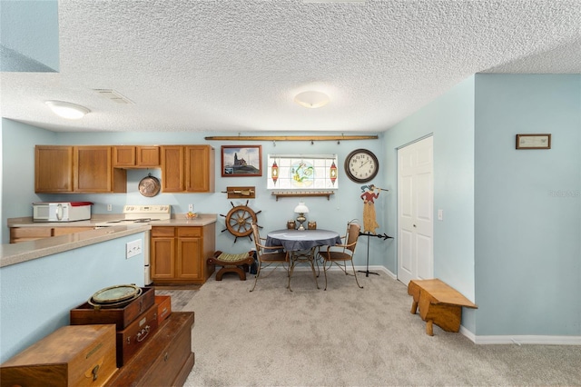 kitchen featuring white appliances, light carpet, and a textured ceiling