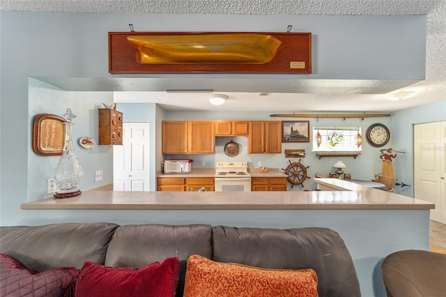 kitchen with kitchen peninsula, a textured ceiling, and electric range