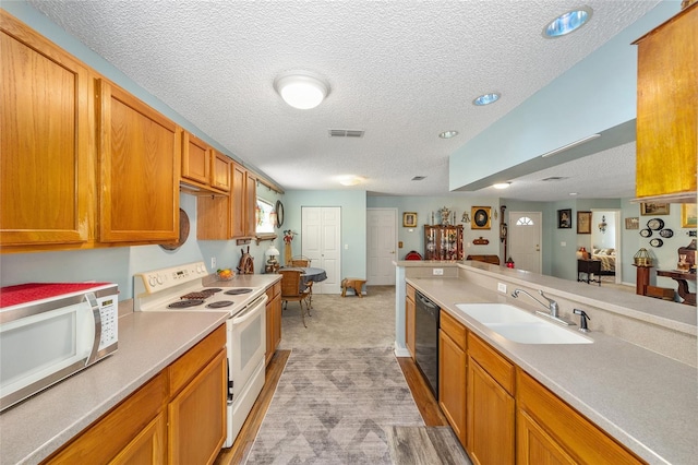 kitchen featuring sink, a textured ceiling, and white appliances