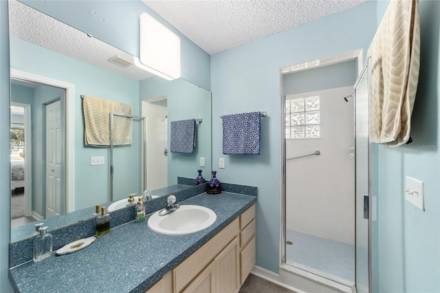 bathroom featuring vanity, an enclosed shower, and a textured ceiling