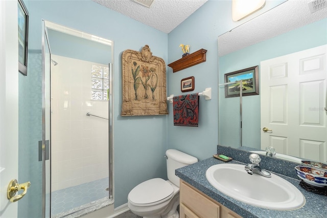 bathroom with vanity, a shower with shower door, toilet, and a textured ceiling