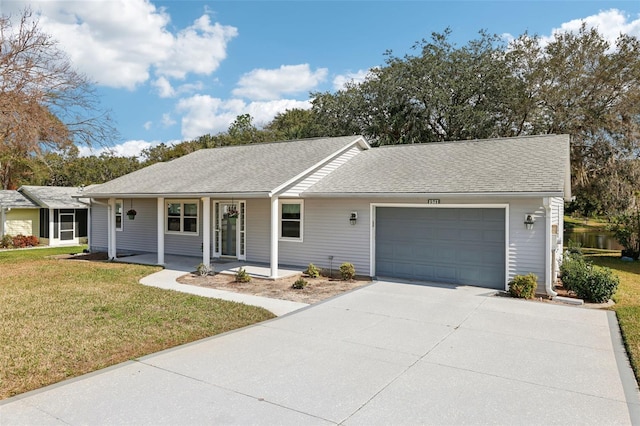 single story home featuring a garage, covered porch, and a front lawn