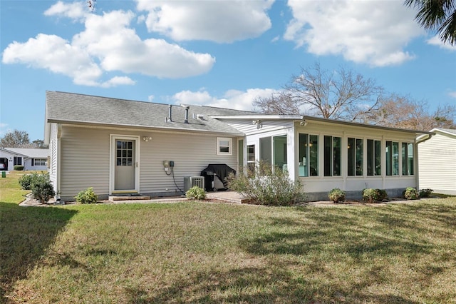 back of house with a sunroom and a lawn