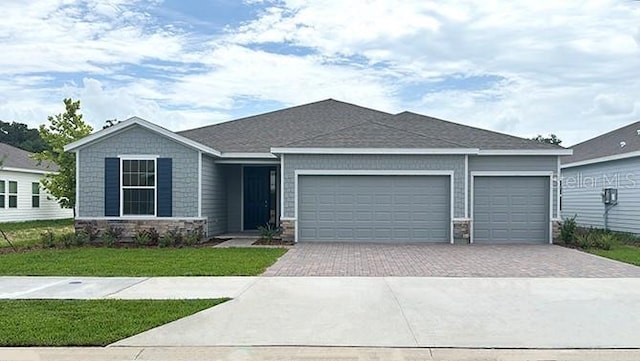 1414 NW 128th Ter, Newberry, FL 32669 - ranch-style home featuring stone siding, decorative driveway, an attached garage, and a front lawn