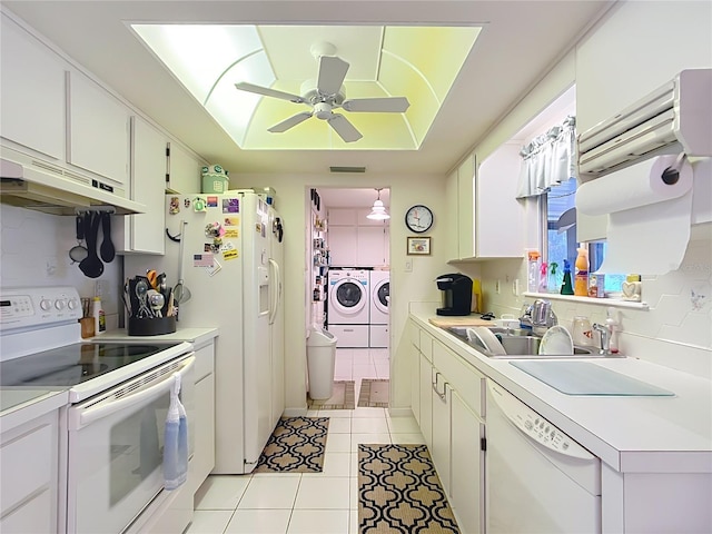 kitchen with white cabinets, white appliances, a tray ceiling, and washing machine and clothes dryer