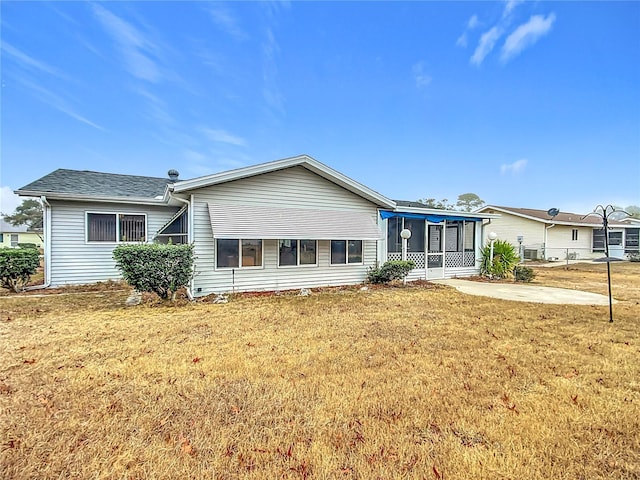 rear view of property with a patio and a lawn