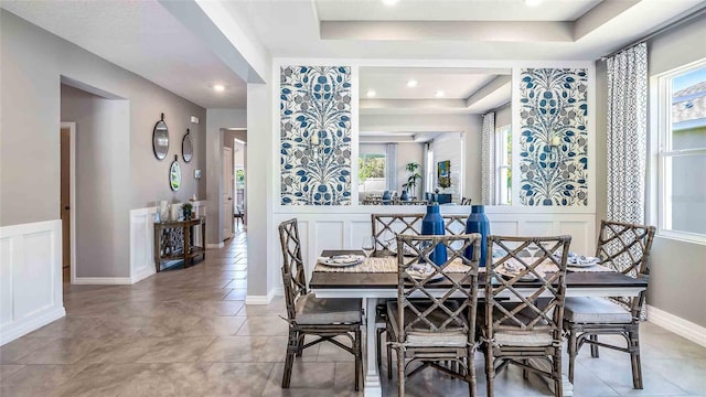 tiled dining area with a raised ceiling