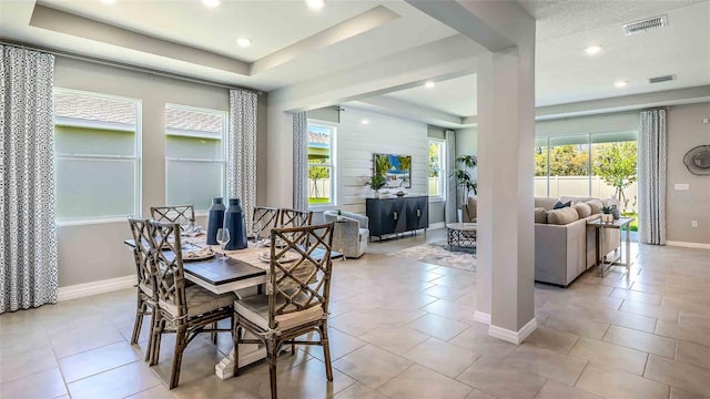 tiled dining room featuring a raised ceiling