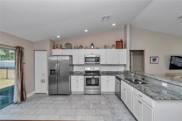 kitchen with appliances with stainless steel finishes, stone countertops, white cabinetry, sink, and kitchen peninsula