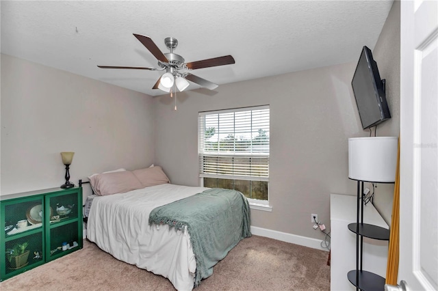 bedroom with ceiling fan, carpet flooring, and a textured ceiling