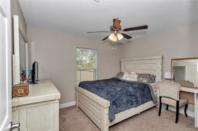 carpeted bedroom with ceiling fan and a textured ceiling