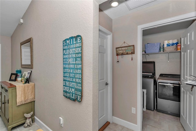 interior space with independent washer and dryer and light tile patterned flooring