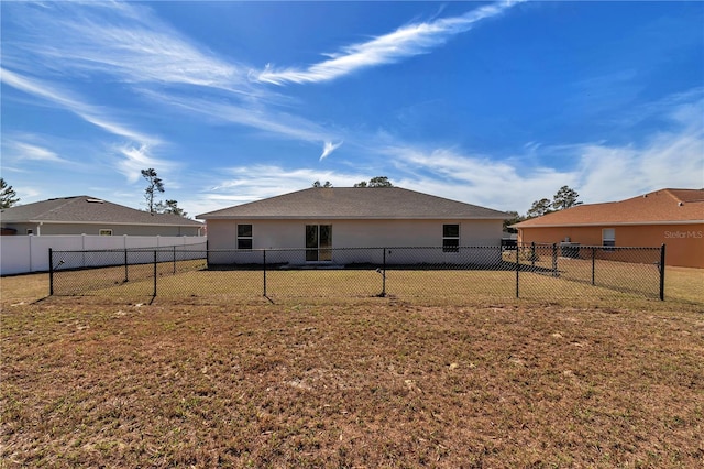 rear view of property featuring a lawn