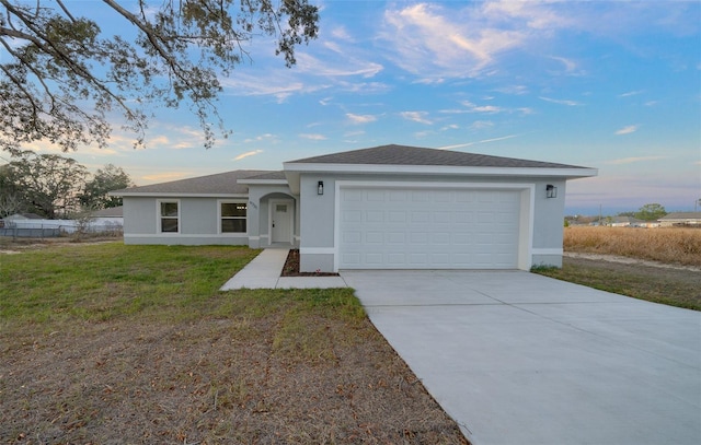 ranch-style house with a garage and a yard