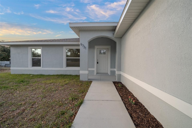 view of exterior entry with a lawn