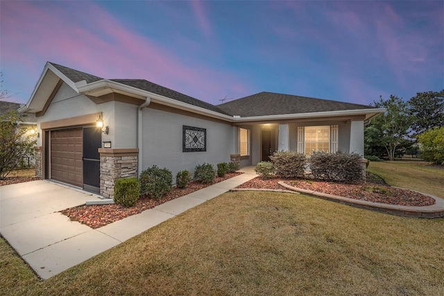 view of front of property with a garage and a yard