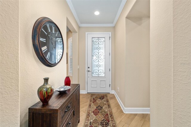 foyer entrance with crown molding and light hardwood / wood-style floors