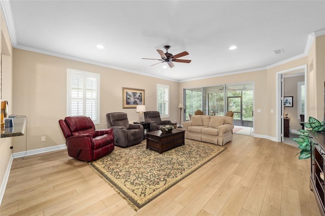 living room with crown molding, a healthy amount of sunlight, and light hardwood / wood-style floors