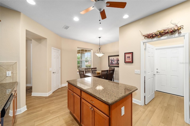 kitchen with pendant lighting, dishwasher, a center island, ceiling fan, and light hardwood / wood-style flooring